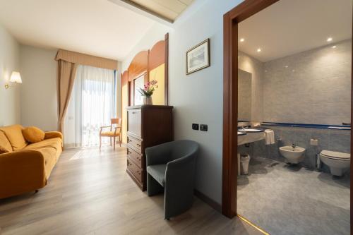 a living room with a couch and a bathroom at Hotel Persico's in San Giovanni in Persiceto