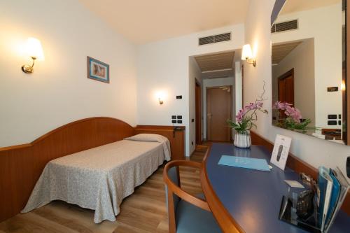 a bedroom with a bed and a desk in a room at Hotel Persico's in San Giovanni in Persiceto