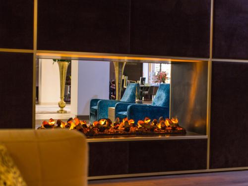 a living room with a fire place in a mirror at Vienna House by Wyndham Andel's Berlin in Berlin