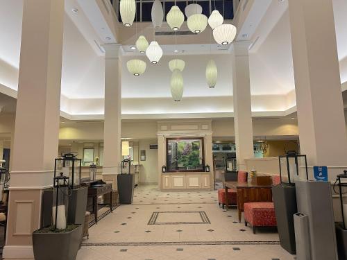 a lobby of a hotel with chandeliers at Arnot Grand Hotel & Suites in Horseheads