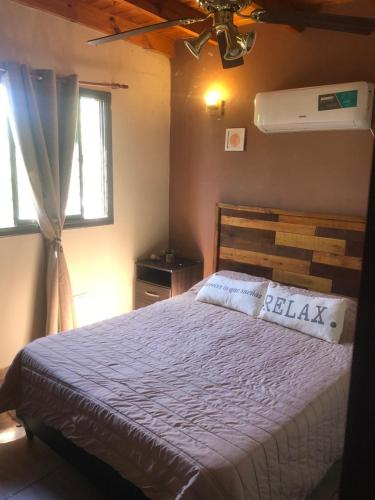 a bedroom with a bed and a window at Complejo Renacer in Villa Parque Siquiman