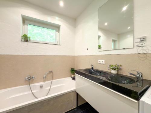 a bathroom with a tub and a sink and a bath tub at Apartment Franz in Sattendorf
