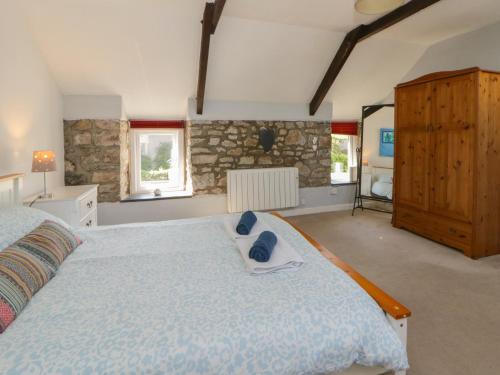 a bedroom with a large bed with a blue comforter at Swallows Retreat in Kilgetty