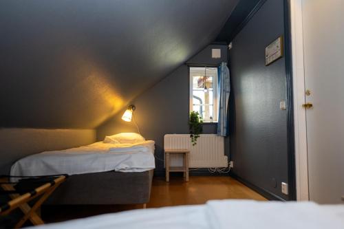 ein kleines Zimmer mit zwei Betten und einem Fenster in der Unterkunft Skutskepparn Kuststation in Nordingrå