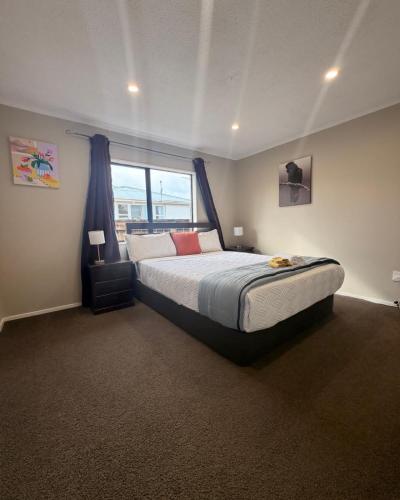 a bedroom with a large bed and a window at Stylish Trentham Retreat in Upper Hutt