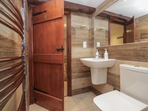a bathroom with a toilet and a sink at Woodloft Cottage in Elterwater