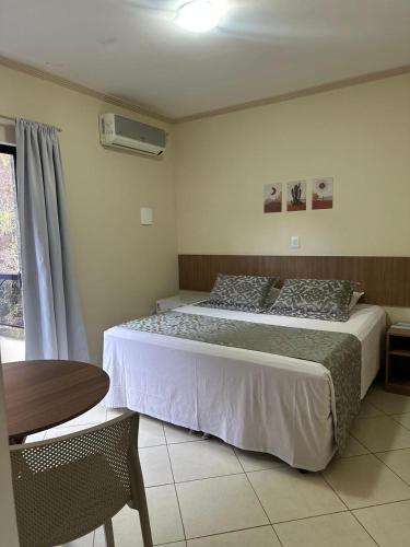 a bedroom with a bed and a table and a window at Imperial Hotel in Santa Bárbara