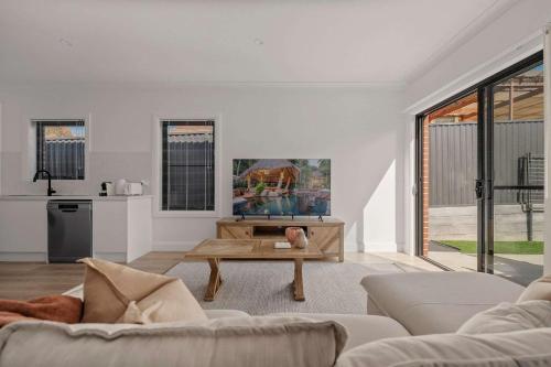 a living room with a couch and a coffee table at Stylish & New 2 Bed & 2 Bath Apartment in Bathurst