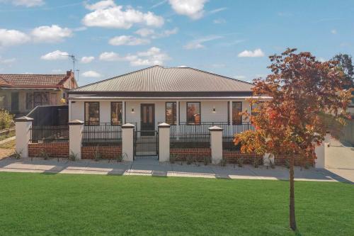 a house with a green lawn in front of it at Stylish & New 2 Bed & 2 Bath Apartment in Bathurst