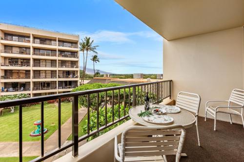 a balcony with a table and chairs and a building at Sugar Beach 304 in Kihei