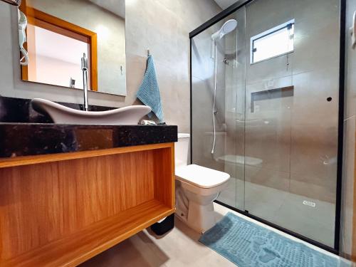 a bathroom with a shower and a sink and a toilet at Centro: Flat p/ 4 pessoas + Vaga in Brusque