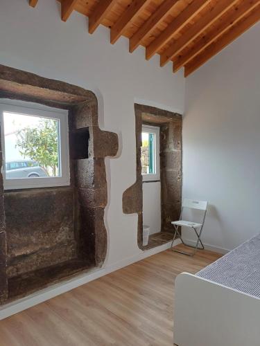 a room with a wall that has a window and a bed at Casa do Galante in Nordeste