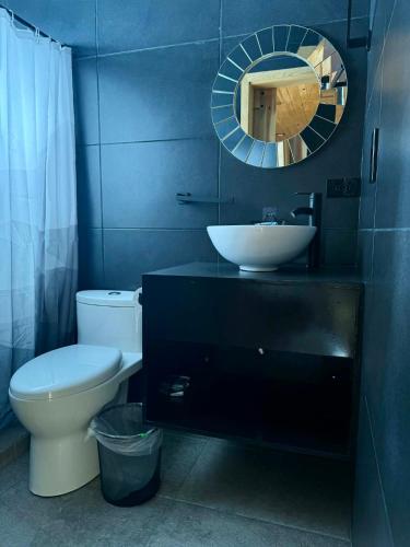 a bathroom with a toilet and a sink and a mirror at Caminante in Creel