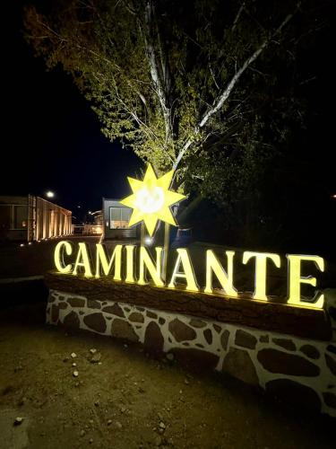 a lit up sign with a campillian sign in the night at Caminante in Creel