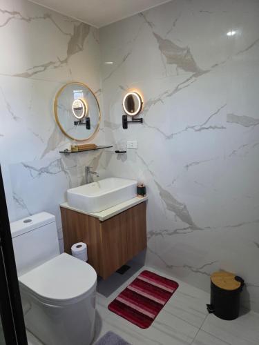 a bathroom with a toilet and a sink and a mirror at Riverduplex - Luxury duplex at a fair price in Dauis