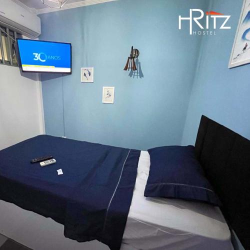 ein Schlafzimmer mit einem Bett und einem Fernseher an der Wand in der Unterkunft Ritz Hostel in Araçatuba