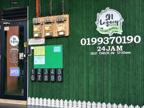 a green wall with a sign on it at Hotel SN Legacy in Kuala Terengganu