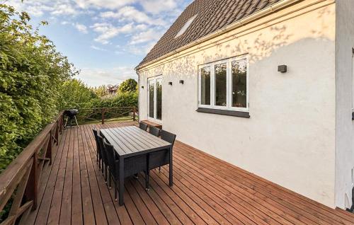 a wooden deck with a bench on a house at 2 Bedroom Awesome Home In Faaborg in Faaborg