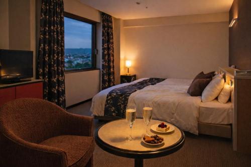 a hotel room with a bed and a table with drinks at The Celecton Fukushima in Fukushima