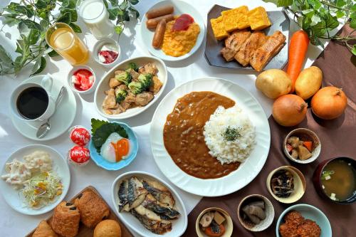 a table topped with plates of food and bowls of food at The Celecton Fukushima in Fukushima