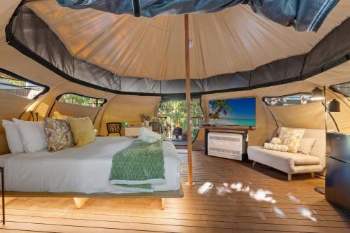 a bedroom in a tent with a bed and a tv at Tamborine Mountain Glades in Mount Tamborine