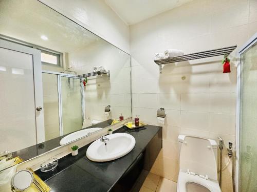 a bathroom with a sink and a toilet and a mirror at Rompin Beach Resorts in Kuala Rompin