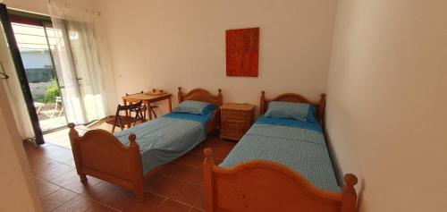 two beds in a room with a table and a window at Piccolo Paradiso Crotone in Casa Margherita