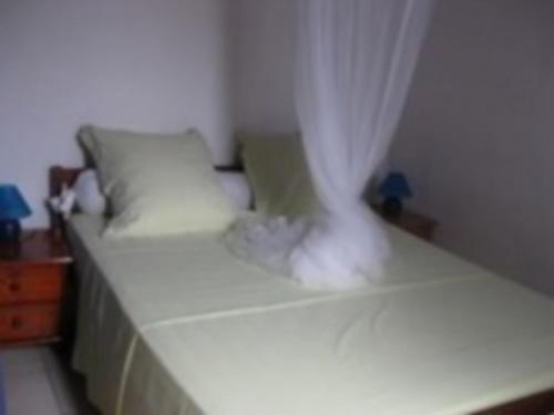 a white bed with a white canopy and pillows at Mon Repos in Sainte-Luce