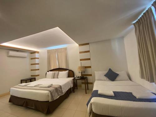 a hotel room with two beds and a window at Metro Vigan Inn MAIN in San Vincente