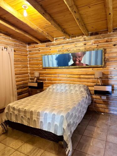 a bedroom with a bed in a wooden wall at Cabaña Manzano Historico Punta Negra Lodge 2 in Tunuyán