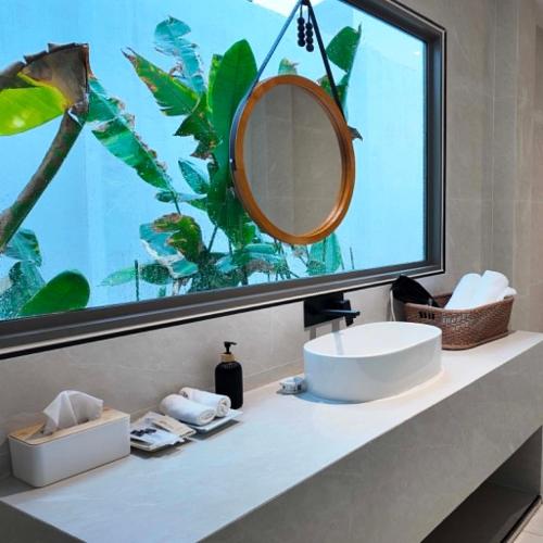 a bathroom with a sink and a large window at Merry Holmes Resort Hatyai in Ban Tha Sae