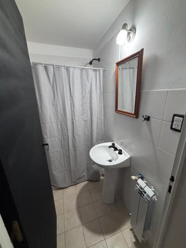a bathroom with a sink and a mirror and a shower at La Serenité en Puerto Madryn in Puerto Madryn