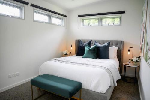 a bedroom with a large bed with blue pillows at Modern Luxuries Guesthouse in Berowra