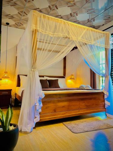 a bedroom with a bed with a mosquito net at LEAFORA Cottage in Galle