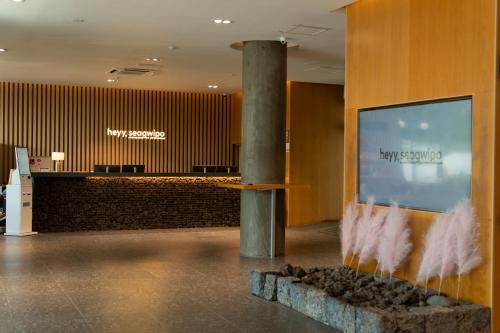 a lobby of a hotel with a waiting area at Heyy Seogwipo Hotel in Seogwipo