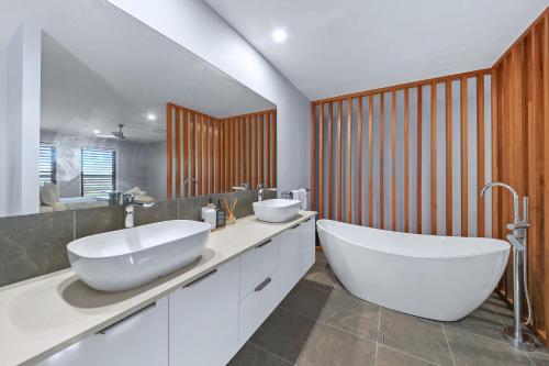a bathroom with two sinks and a large tub at Sunshine Coast Escape | Beachside, Pool & Views in Kawana Waters