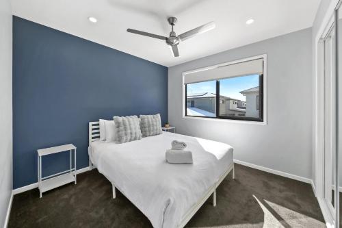a blue bedroom with a bed and a window at Sunshine Coast Escape | Beachside, Pool & Views in Kawana Waters