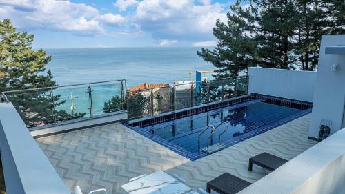 a swimming pool with a view of the ocean at Yeongdeok Full Moon Pool Villa in Yŏngdŏk