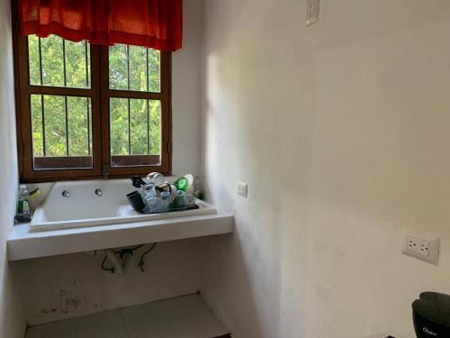 a bathroom with a sink and a window at Antigua Mariana Hotel Boutique in Cedro