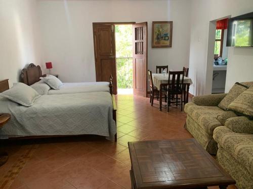 a living room with a bed and a couch and a table at Antigua Mariana Hotel Boutique in Cedro