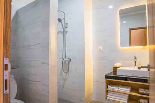 two images of a bathroom with a shower and a sink at Sandat Mas Uluwatu in Uluwatu