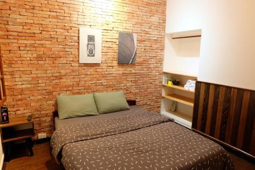 a bedroom with a bed in front of a brick wall at Villa Aqua Da Lat in Da Lat