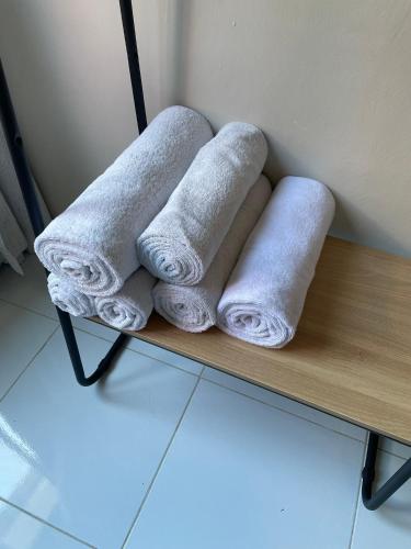 a pile of towels sitting on a wooden shelf at Casa de Lisa in Tjakranegara