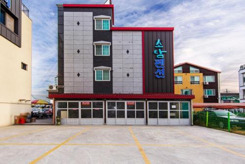 a large building with a parking lot in front of it at Daecheon Sodam pension in Boryeong