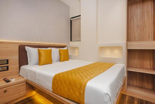 a bedroom with a large bed with yellow pillows at Hotel Lexus7 in Mumbai