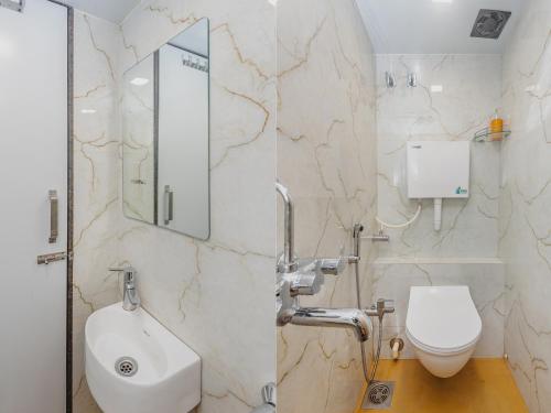 a bathroom with a toilet and a sink and a mirror at Hotel Lexus7 in Mumbai