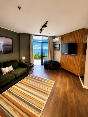 a living room with a couch and a television at Apartamento Vista Ponte in Niterói