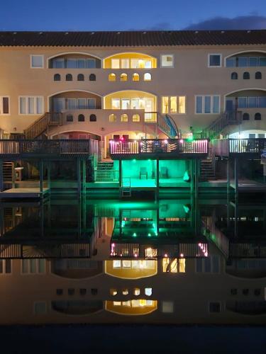 a building at night with its reflection in the water at La Sirena Pescadora in Corpus Christi