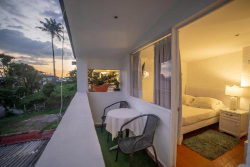 a room with a balcony with a bed and a table at Posada del Angel in Salento