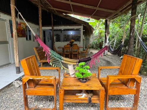 a patio with two chairs and a table and a hammock at Quinto Hotel in Palomino